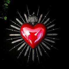 a red heart with silver spikes on it