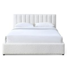 the bed is made up with white sheets and pillows