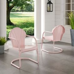 two pink chairs sitting on top of a patio