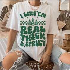 a woman sitting on top of a basket wearing a white shirt that says i like em rear the back and sprout