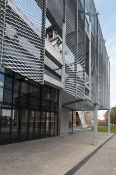 an empty parking lot in front of a building with metal balconies on it