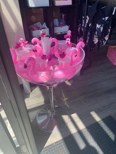 a glass bowl filled with pink candles on top of a table