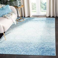 a living room with a white couch and blue rug