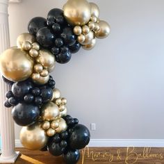 black and gold balloons are hanging on the wall