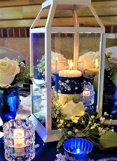 there is a candle and some flowers in the vases on the table with candles