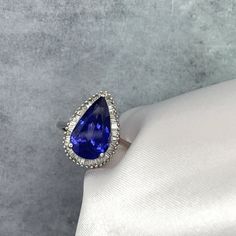 a tan and white ring with a blue tear shaped stone on it's side