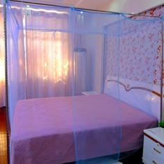 a bedroom with a purple bed and white dressers