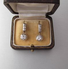 Antique 14K yellow and white gold drop earrings with diamonds, lever back. With an Austrian hallmark that was used between 1867 and 1937. Gemstone: Natural diamond, 2 pieces Weight: 1.3 carat Color: Crystal (I/J) Clarity: SI2 Measurements: Round, 5.8 x 3.16 mm each Cut: Old Cut Brilliant Finish: Corresponds to old cut requirements Fluorescence: none Not treated. Additional stones: Natural diamond, 6 pieces Measurements: 2.4 mm Weight: 0.3 carat Cut: Old Cut Brilliant Color: Crystal (I/J) Clarity Classic Hallmarked Yellow Gold Diamond Earrings, Vintage Gold Diamond Earrings With Brilliant Cut, Vintage Hallmarked White Gold Earrings, Classic Hallmarked Diamond Earrings For Formal Occasions, Classic Hallmarked Diamond Earrings For Formal Events, Victorian Brilliant Cut Diamond Earrings For Anniversary, Antique Round Diamond Anniversary Earrings, Antique Round Diamond Earrings For Anniversary, Victorian Style Round Diamond Earrings For Formal Occasions