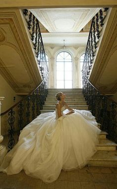 a woman in a wedding dress sitting on some stairs