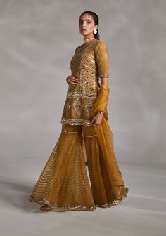 Editor's Note A sharara set covered in mirror details for the scintillating look Color: Olive green Fabric: Silk, organza Fit type: Kurti: fitted Components: Kurti, sharara and dupatta Occasion: Haldi mehndi and Wedding Guest Care: Dry Clean Only About the Designer The crux and essence of the label, Divya Aggarwal, is to challenge and revamp the face of ordinary traditional wear while being customer oriented. Driven by the values of individuality and creativity, this contemporary Indian couture Divya Aggarwal, Silk Sharara, Yellow Mirror, Olive Green Fabric, Blouse Yoke, Yellow Kurta, Bead Embellishment, Beaded Neckline, Indian Couture