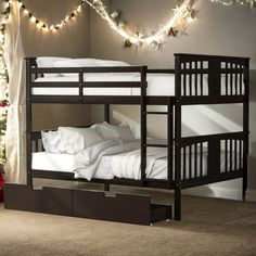 there is a bunk bed with white sheets and pillows on the bottom level, next to a christmas tree