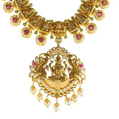 Designed with the elegance, this 22k antique gold Lakshmi necklace set by Virani Jewelers features rubies, emeralds, pearls and cubic zirconia stones. The antique gold finish offers a sophisticated, vintage look, while the gemstones add a vibrant contrast. Ideal for formal events and celebrations, this 22k gold Lakshmi necklace is a beautiful representation of traditional craftsmanship, blending heritage and contemporary style for those who appreciate luxurious, meaningful Indian jewelry.Features• 22k yellow gold• Antique finish• Engraved details• Emerald• Ruby • Pearl• Cubic zirconiaSpecifications:• Minimum Width - 2.5 millimeters• Maximum Width - 61.6 millimeters• Length - 30 inches• Weight - 111.7 grams Traditional Luxury Engraved Necklaces, Luxury Antique Gold Ceremonial Necklace, Luxury 22k Gold Engraved Necklaces, Luxury Antique Necklaces For Celebration, 22k Gold Necklace Indian Jewelry Kameswari Jewellers, Luxury Traditional Pearl Necklace With Gemstones, Luxury 22k Gold Emerald Necklace For Celebration, Luxury Antique Formal Jewelry, Gold Necklace Set Indian Kameswari Jewellers