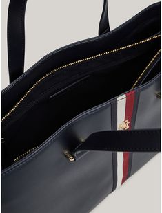 Tommy Hilfiger women's bag. Signature branding and gold-tone hardware set the tone of this sophisticated tote bag, complete with dual carry handles for comfortable toting. It also features side zips and an expandable lining to change its shape and add room to the main compartment.  Material: 100% Polyurethane. Business Shoulder Bag With Double Handle And Branded Hardware, Tommy Hilfiger Shoulder Bag With Removable Pouch, Elegant Tommy Hilfiger Leather Shoulder Bag, Tommy Hilfiger Bag With Removable Pouch For Everyday, Tommy Hilfiger Leather Shoulder Bag For Daily Use, Elegant Tommy Hilfiger Shoulder Bag For Travel, Elegant Tommy Hilfiger Leather Bag, Double Handle Bags With Gold-tone Hardware, Business Tote Satchel With Branded Hardware