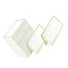 three white cards with gold trims on each side and one is folded in half