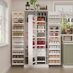 an organized pantry with lots of items in the shelves and on the floor next to a window