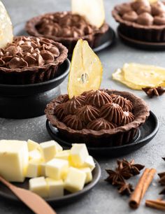 chocolate tarts and other desserts on black plates