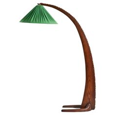 a wooden floor lamp with a green shade