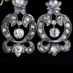 "Georgian silver topped 14k gold drop earrings with over 5 carats of diamonds feature a combination of old mine cut and rose cuts. The stunning earrings have been preserved for nearly 200 years. One has been repaired at some point in its history of ownership. The bottom flourish was reattached and the top of the pendulous was reinforced and reattached. See detailed imagery of repairs. These have not been cleaned by us in case of foil backings on non open backed stone mountings, which were preval Formal Rose Cut Diamond Chandelier Earrings, Formal Chandelier Earrings With Rose Cut Diamonds, Luxury Rose Cut Diamond Chandelier Earrings For Wedding, Luxury Silver Chandelier Earrings With Rose Cut Diamonds, Elegant Chandelier Earrings With Rose Cut Diamonds, Formal Silver Rose Cut Diamond Earrings, Luxury White Gold Bridal Earrings With Rose Cut Diamonds, Antique White Gold Diamond Earrings, Antique Diamond White Earrings With Diamond Accents