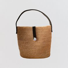 This raffia handbag is the perfect summer companion. Made from natural raffia fibers, it is lightweight, durable and environmentally friendly. Its light tea color easily matches all summer outfits. The bag is hand-woven, which gives it a unique artisanal appearance. It has two leather handles, which are long enough to be carried on the shoulder or in the hand. ▫️ NATURAL MATERIAL ▫️ HANDMADE ▫️ ECO-FRIENDLY Beige Straw Shoulder Bag With Round Handle, Eco-friendly Woven Beige Straw Bag, Beige Crochet Straw Bag With Round Handle, Chic Jute Straw Bag With Round Handle, Beige Woven Straw Bag With Round Handle, Chic Natural Straw Bag With Round Handle, Natural Woven Bucket Bag For Daily Use, Handwoven Summer Bucket Bag For Everyday, Light Brown Woven Straw Tote Bag