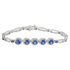 This elegant 18KT white gold bracelet features a total of 3.00CT of round-cut genuine Ceylon blue sapphires, adding a vivid and captivating touch. The sapphires are beautifully complemented by 1.56 carats total weight of G-VS/SI round-cut diamonds, set in the finest 18KT white gold. This combination of vibrant blue sapphires and sparkling diamonds creates a sophisticated and luxurious accessory, making it a timeless addition to any jewelry collection. Elegant White Gold Sapphire Diamond Bracelet, Luxury Blue Sapphire Bracelets, Luxury Sapphire Diamond Bracelet, Luxury Sapphire Jubilee Bracelet, Luxury Sapphire Diamond Bracelet, Brilliant Cut, 77 Diamonds, Ceylon Blue Sapphire, Diamond Huggie Earrings, Ruby Bracelet