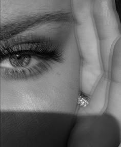 a woman's eyes are shown with her hand on her face