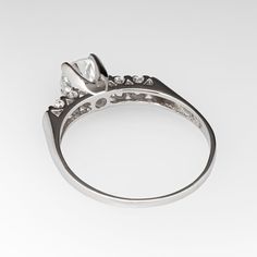 This lovely vintage engagement ring is centered with a round brilliant cut diamond weighing 0.82 carats and set into a four-prong head. The shoulders of the ring are each accented with two (2), prong set, round single cut diamonds. The ring measures 5.8mm at the top, rises 7.1mm above the finger, tapering to 1.3mm wide and 0.6mm thick at the base of the shank. The ring is currently a size 9 and we offer complimentary resizing to fit. Timeless Classic Cut Diamond Ring With Single Cut Diamonds, Timeless Diamond Ring With Single Cut, Timeless Diamond Ring With Single Cut Diamonds, Timeless Round Cluster Ring With Prong Setting, Timeless Rings With Classic Cut Single Diamonds, Classic Round Diamond Cluster Ring, Classic Round Cluster Diamond Ring, Diamond Ring With Classic Cut Center Stone, Heirloom Diamond Ring With Vvs Clarity In Round Cut