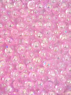 many pink bubbles are floating in the air with white dots on it's surface