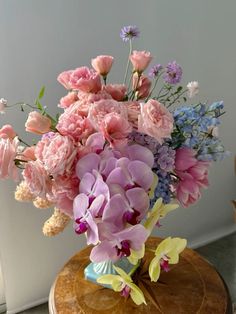 a vase filled with lots of pink and purple flowers