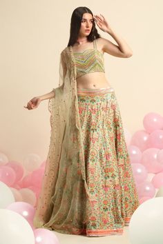 Mint green printed lehenga with neon embroidery in floral motifs. Paired with embroidered blouse and organza dupatta.
Component: 3
Pattern: Embroidered,Printed
Type Of Work: Floral
Neckline: Sweetheart
Sleeve Type: Sleeveless
Fabric: Organza, Dupion Silk
Color: Green
Other Details: 
Floral print
Scallop dupatta
Striped blouse
Occasion: Destination Wedding - Aza Fashions Printed Lehenga, Dupion Silk, Organza Dupatta, Green Print, Half Saree, Sweetheart Neck, Bridal Lehenga, Embroidered Blouse, Striped Blouse