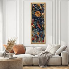 a living room filled with furniture and a painting hanging on the wall over a white couch