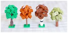 four lego trees are lined up in different colors