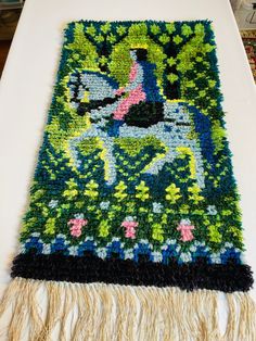 a table with a rug on top of it that has flowers and plants on it