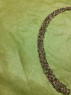 a necklace is laying on a green cloth