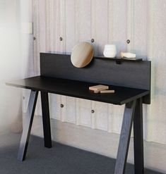 a black table with two plates on it next to a curtained window in a room