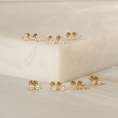 Dainty, adorable, and incredibly sparkly - the Triple Diamond Flat Back Earrings will be your new favorite studs. Crafted in gorgeous 14k solid gold and lab-grown diamonds, these studs are both light and durable, offering a touch of confident sparkle throughout your daily adventures. DETAILS 14k solid gold flat back earring with 4mm internal thread 3.5mm width Post: 6.5mm length, 18 gauge Three lab-grown diamonds: 1.5mm Diamond carat: 0.042 ct Diamond color & clarity: DEF-SI Weight: 0.21g Availa Single Stone Studs, Types Of Gold, Flat Back Earrings, Gold Flats, Ring Size Guide, Favorite Rings, Diamond Color, Diamond Carat, Stud Earring