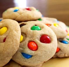 a pile of cookies with m and m candies on them sitting on a table