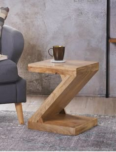 a wooden table sitting on top of a carpeted floor next to a gray chair