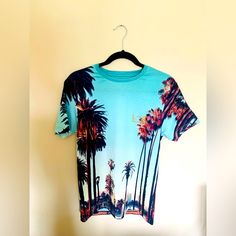 Brand New W/ Tags. River Island Men's T-Shirt Palm Tree Graphic Print Los Angeles Logo Print Crew Neck Short Sleeve 95% Polyester, 5% Elastane Cool Iron Machine Wash At Max 40c Gentle Do Not Bleach Do Not Tumble Dry Do Not Dry Clean Casual Cotton Tops With Palm Tree Print, Casual Cotton Top With Palm Tree Print, Palm Tree Print Graphic Tee With Crew Neck, Relaxed Fit Cotton T-shirt With Palm Tree Print, Cotton T-shirt With Palm Tree Print In Relaxed Fit, Cotton Crew Neck Top With Palm Tree Print, Relaxed Cotton Top With Palm Tree Print, Casual Crew Neck Top With Palm Tree Print, Casual Cotton T-shirt With Palm Tree Print