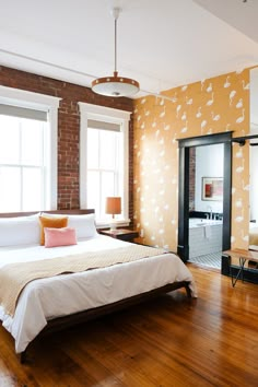 a bed room with a neatly made bed next to a window