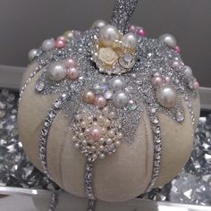 a decorative pumpkin with pearls and jewels on it