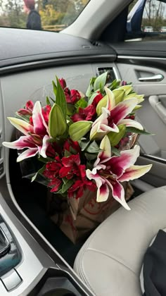 a bouquet of flowers sitting in the center console of a car