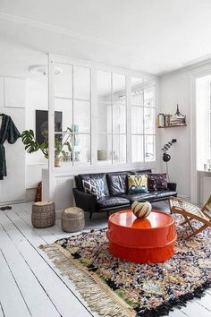 a living room filled with furniture and a rug on top of a hard wood floor