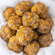 a pile of meatballs sitting on top of a white paper towel covered in cheese