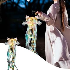 a woman in white dress standing next to a light up giraffe