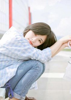 a woman crouches down to pick up something from the ground