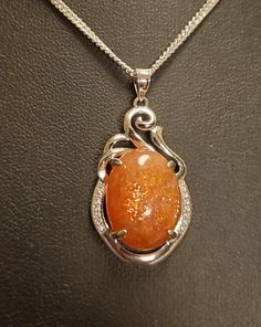 "Sparkling Natural Sunstone Necklace, 13x17mm Orange Schiller Stone, 925 Sterling Silver Swirl Top Pendant With Tiny Cubic Zirconia Trim. 20\" Sterling Chain. Chain Length Options Available By Messaging Seller At Time Of Purchase. Gift Box Included." Luxury Orange Faceted Necklace, Sunstone Necklace Pendants, Orange Gem Necklace, Orange Stone Necklace, Luxury Orange Necklace With Natural Stones, Magic Amulet Necklace, Gem Necklace Stones, Silver Oval Necklace With Sparkling Stones, Oval Sparkling Jewelry Gift