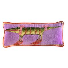 a purple pillow with an image of a dinosaur on the front and bottom, along with orange trimmings