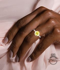 a close up of a person's hand with a yellow flower on their ring