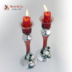 two red candles are sitting in glass holders