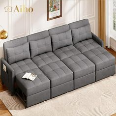 a grey couch sitting on top of a wooden floor next to a white rug in a living room